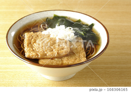 油揚げ2枚とワカメと葱が乗った熱々のきつね蕎麦 108306165