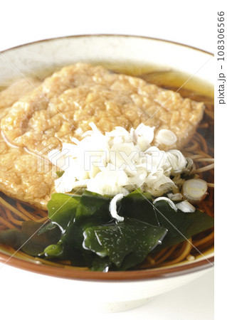 油揚げ2枚とワカメと葱が乗った熱々のきつね蕎麦を白背景で撮影 油揚げ2枚とワカメと葱が乗った熱々のきつね蕎麦を白背景で撮影 108306566