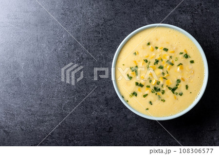 Corn soup in green bowl on black background 108306577