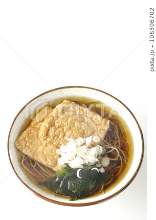 油揚げ2枚とワカメと葱が乗った熱々のきつね蕎麦を白背景で俯瞰撮影 油揚げ2枚とワカメと葱が乗った熱々のきつね蕎麦を白背景で俯瞰撮影 108306702