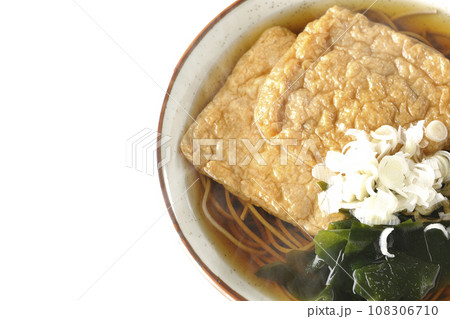 油揚げ2枚とワカメと葱が乗った熱々のきつね蕎麦を白背景で俯瞰撮影 油揚げ2枚とワカメと葱が乗った熱々のきつね蕎麦を白背景で俯瞰撮影 108306710