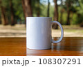 A white mug placed on a log with a view of nature in the background. 108307291