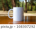 A white mug placed on a log with a view of nature in the background. 108307292