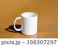 A white mug placed on a log with a view of nature in the background. 108307297