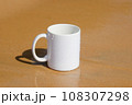 A white mug placed on a log with a view of nature in the background. 108307298