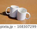 A white mug placed on a log with a view of nature in the background. 108307299