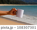 A white mug placed on a log with a view of nature in the background. 108307301