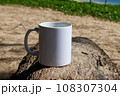 A white mug placed on a log with a view of nature in the background. 108307304