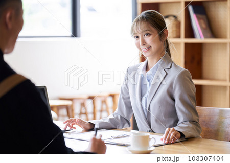 飲食店の経営者に営業をするアジア人ビジネスウーマン 108307404