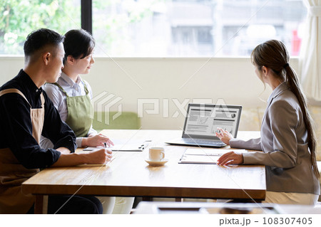 飲食店の経営者に営業をするアジア人ビジネスウーマン 108307405