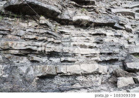 Cliffs in East Cliff beach in Lyme Regis, Dorset, South West England. Close up of stacked under time stones. Selective focus 108309339