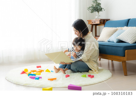 子供を抱っこしながらパソコンを見るお母さん 子供を抱っこしながらパソコンを見るお母さん 108310183