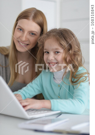 Mother and daughter looking at laptop computer Mother and daughter looking at laptop computer 108310843