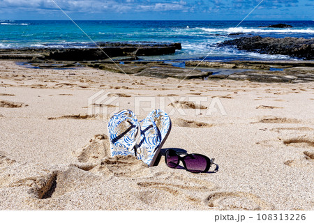 Flip flops and sunglass on Playa de los Ojos - Fuerteventura, Canary Islands, Spain 108313226