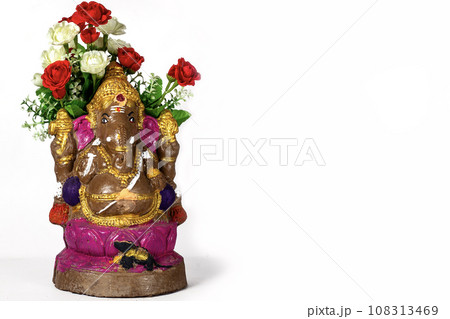 Happy Ganesh Chaturthi Festival - Beautiful Ganesh statue made of clay with flowers on white background. Happy Ganesh Chaturthi Festival - Beautiful Ganesh statue made of clay with flowers on white background. 108313469