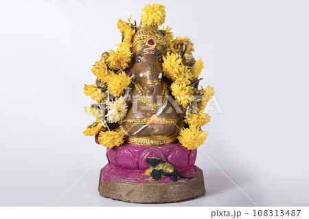 Beautifully painted clay Ganesh statue with garland on white background. Beautifully painted clay Ganesh statue with garland on white background. 108313487