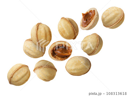 Cookies shaped like nuts and halves fly close-up on a white background. Cookies shaped like nuts and halves fly close-up on a white background. 108313618