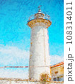 Popular white lighthouse with a concrete tower and an active light by a quiet beach. 108314011