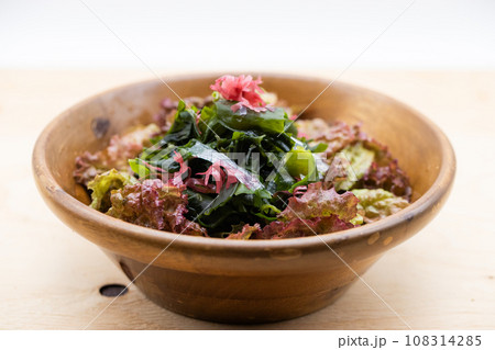 木のボールに入っている海藻サラダ 108314285