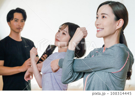 トレーナー指導者のもとストレッチをする女性 トレーナー指導者のもとストレッチをする女性 108314445