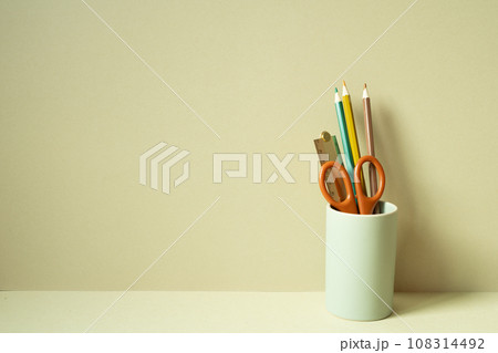 Writing supplies pencil holder on desk. khaki beige background Writing supplies pencil holder on desk. khaki beige background 108314492