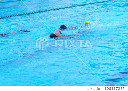 child swimmer swim in swimming pool. Water sports training and competition, learning to swim classes for children child swimmer swim in swimming pool. Water sports training and competition, learning to swim classes for children 108317225