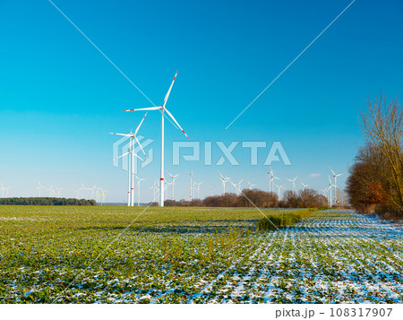 Wind turbines and agricultural field on winter day. 108317907