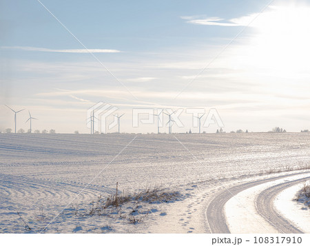 Wind turbines and agricultural field on winter day. 108317910