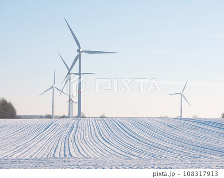 Wind turbines and agricultural field on winter day. 108317913