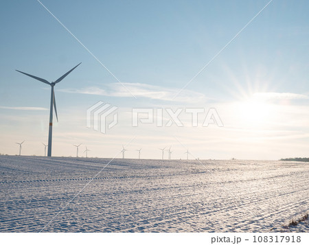 Wind turbines and agricultural field on winter day. Wind turbines and agricultural field on winter day. 108317918