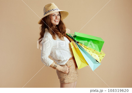 smiling elegant woman in blouse and shorts on beige smiling elegant woman in blouse and shorts on beige 108319620