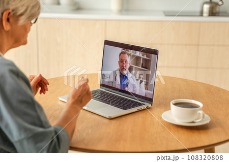 Senior man doctor expert examining older senior woman online. Old woman lady patient and doctor talk on video call have consultation with laptop. Medicine healthcare medical checkup. Online doctor 108320808