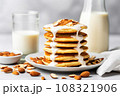 almond milk drizzling on a stack of pancakes 108321906