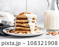 almond milk drizzling on a stack of pancakes 108321908