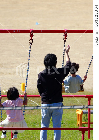 公園でブランコで遊ぶ 108323394