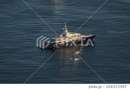 Monaco, lonely mega yacht in sea at sunset, huge motor boat, wealth life of billionaires  108323487