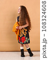 little model girl with long brown hair in designer floral dress, yellow jacket and military boots  108324608