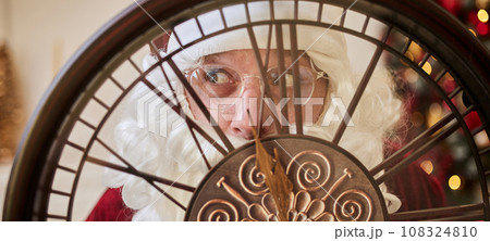 Five minutes to New year or Christmas midnight. Happy Santa Claus shows on the clock Five minutes to New year or Christmas midnight. Happy Santa Claus shows on the clock 108324810