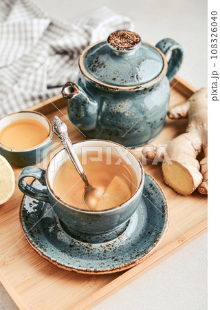 Ginger tea with lemon in a blue cup Ginger tea with lemon in a blue cup 108326040