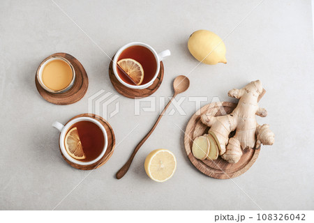 Tea  in a white cups with lemon, ginger root 108326042