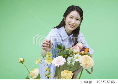 Recycling supplies_Woman looking at and touching flowers image 108328163
