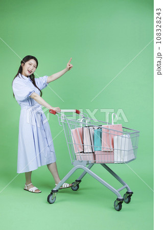 Image of green consumer_woman with shopping cart and shopping bag gift box 108328243