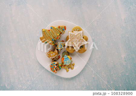 White plate with colorful gingerbread on a blue scratched background 108328900