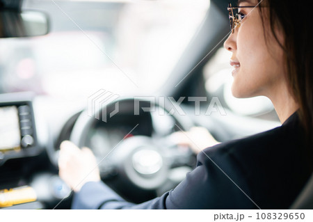 ドライブをするメガネをかけた若い女性 108329650