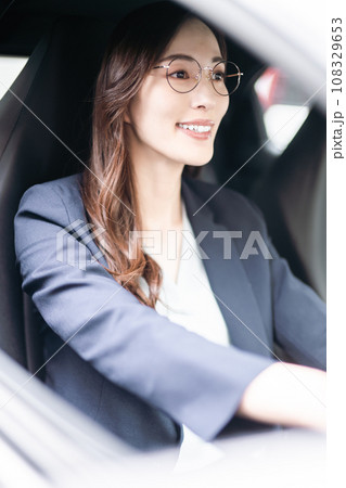 ドライブをするメガネをかけた若い女性 108329653