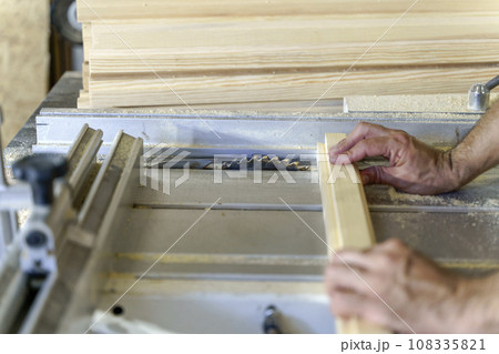A carpenter working with wood in a carpentry workshop. Furniture manufacture 108335821