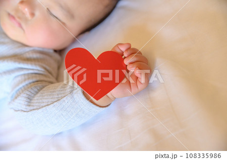 手にハートを持つベッドで寝る赤ちゃん 乳幼児 寝かしつけ 昼寝 寝顔 育児休暇 0歳乳幼児 手にハートを持つベッドで寝る赤ちゃん 乳幼児 寝かしつけ 昼寝 寝顔 育児休暇 0歳乳幼児 108335986