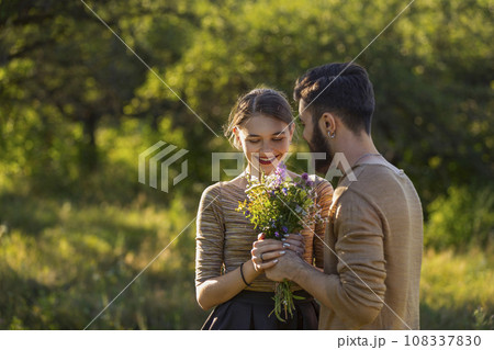 guy gives flowers to his girlfriend guy gives flowers to his girlfriend 108337830