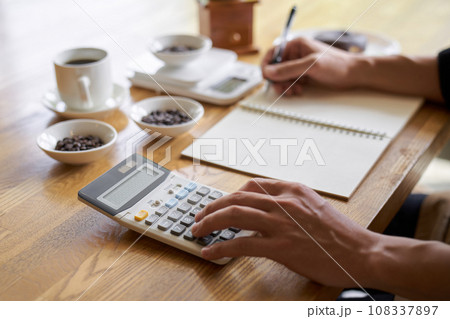 コーヒーの原価を計算するアジア人男性 108337897