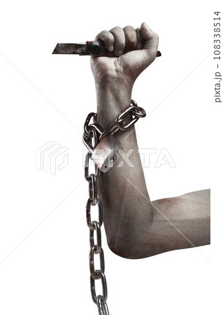 The hand of a scary zombie with blood and wounds holding a knife while tied to the iron chain 108338514